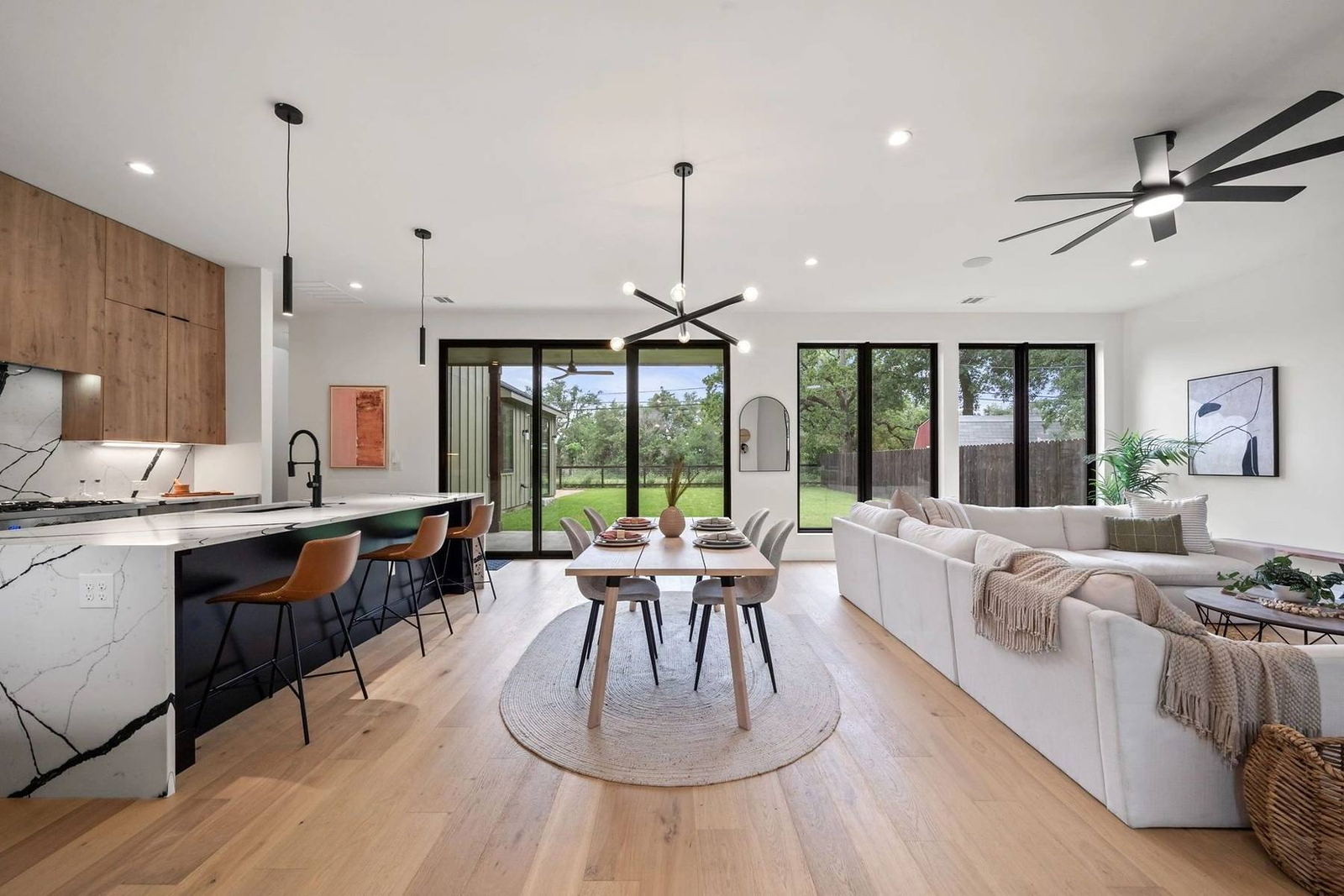Great room with wide-plank oak floors and full-height sliding glass doors