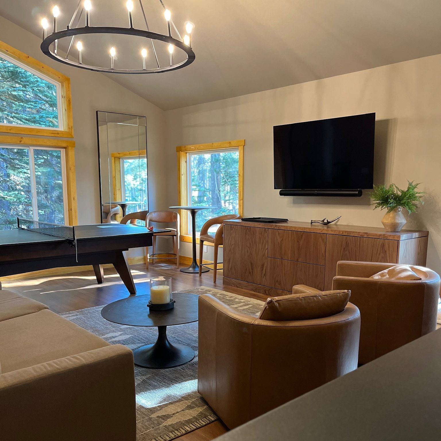 Vaulted great room with a ring chandelier, tall windows and built-in cabinetry in a Lane Built renovation
